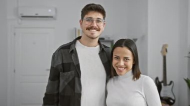 Mutlu bir çift, erkek ve kadın, modern bir oturma odasında poz veriyorlar, elinde evin anahtarları olan kadınla..