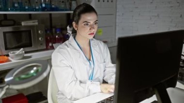 Bir bilgisayar kullanırken laboratuvarda araştırma yapan İspanyol kadın bilim adamı.