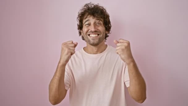 一个快乐的年轻人用紧握着的拳头在坚实的粉红墙上欢庆 传达着兴奋和成功 — 图库视频影像