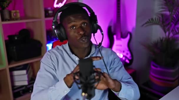 Афро Американський Чоловік Розмовляє Навушниками Мікрофоном Барвистій Ігровій Кімнаті Вночі — стокове відео