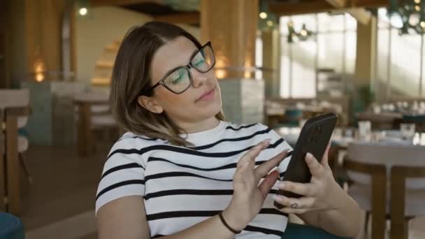 Uma Jovem Mulher Óculos Usa Smartphone Restaurante Moderno Retratando Uma — Vídeo de Stock