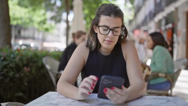 히스패닉 안경을 우연히 테이블에 그녀의 스마트 — 비디오