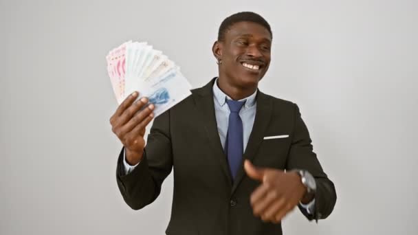 アフリカ系アメリカ人男性がスーツを着て 巨大な笑顔を浮かべ 中国人民元紙幣を展示しながら指を指差した 純粋な白い背景のすべて — ストック動画