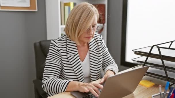 Dojrzała Blondynka Doświadcza Bólu Szyi Podczas Pracy Laptopem Nowoczesnym Biurze — Wideo stockowe