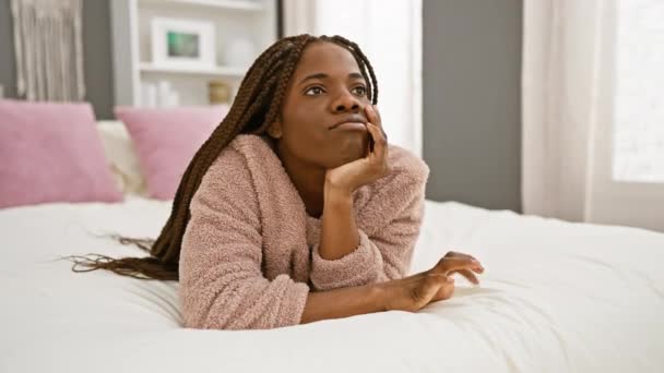 Przemyślana Afrykańska Kobieta Warkoczami Leżąca Łóżku Domu Prezentująca Zrelaksowane Wnętrze — Wideo stockowe