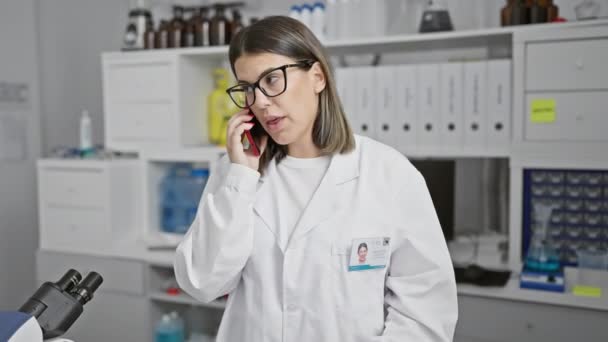 Молодая Женщина Ученый Лабораторном Халате Пользуется Телефоном Современной Лаборатории Помещении — стоковое видео