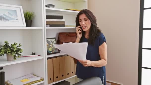 Зріла Жінка Багатозадачна Офісі Розмовляє Телефону Тримаючи Документи Демонструє Продуктивність — стокове відео