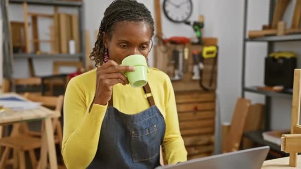 Afrikanische Handwerkerin Trinkt Kaffee Einer Tischlerei Während Sie Laptop Benutzt — Stockvideo