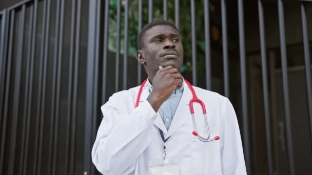 Пасічний Африканський Лікар Білому Пальто Стетоскопом Стоїть Перед Клінічними Воротами — стокове відео