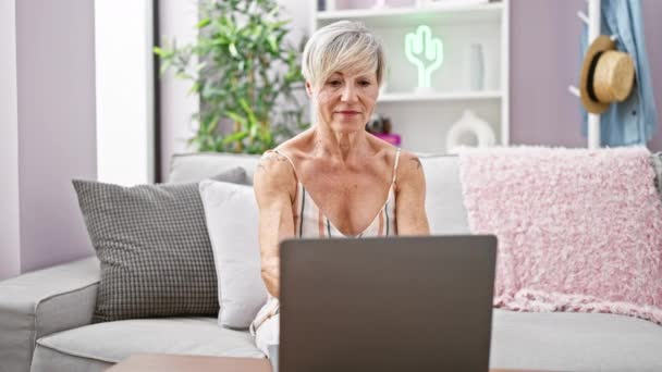 Kısa Gri Saçlı Olgun Bir Kadın Dizüstü Bilgisayarını Kapatırken Oturma — Stok video