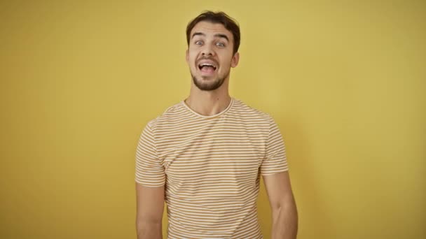 스트라이프 티셔츠에 히스패닉 노란색 배경에 성공의 영리한 제스처에 손가락을 가리키는 — 비디오
