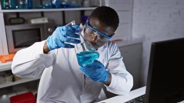 Skupiony Afrykański Naukowiec Analizujący Niebieskie Rozwiązanie Chemiczne Nowoczesnym Laboratorium — Wideo stockowe