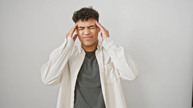 A young man appears stressed or in discomfort against a white background, touching his temples with a pained expression. clipart