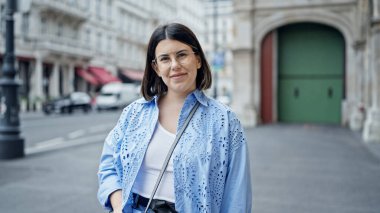 Viyana sokaklarında kendine güvenen güzel İspanyol kadın gülümsüyor.