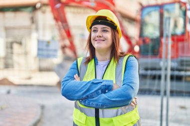 Young beautiful plus size woman architect smiling confident standing with arms crossed gesture at street