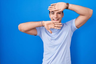 Mavi arka planda dikilmiş, gülümseyen, gülümseyen, elleri havada bir ufaklığa bakan İspanyol bir adam. Şaşırdım ve çıktım. 