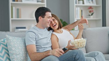 Kanepede oturup mısır yiyen güzel bir çift.