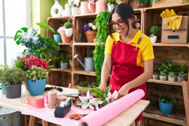 Genç, güzel Arap kadın çiçekçi çiçekçide çiçek buketi yapıyor.
