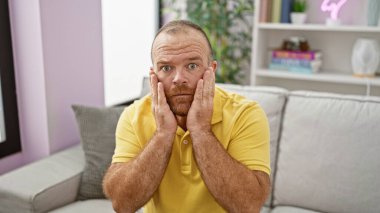 Kanepede oturan beyaz adam şaşırdı.