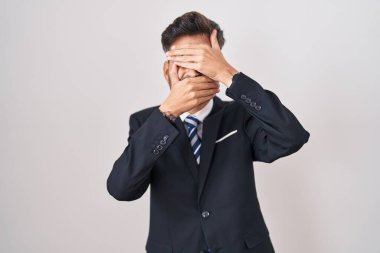 Dövmeli, takım elbiseli, kravatlı gözleri ve ağzı elleri bağlı, şaşırmış ve şok olmuş genç bir İspanyol. duygu gizleme 