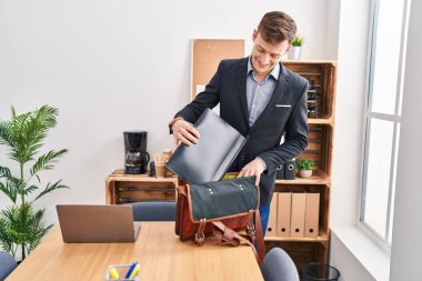 Young man business worker holding binder of briefcase at office