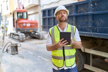 Middle age man architect using touchpad at street