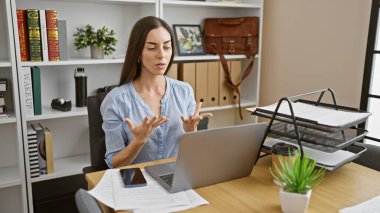 Çekici, genç İspanyol kadın işçi, ofis masasındaki video aramasıyla iş oyununu kapıyor.