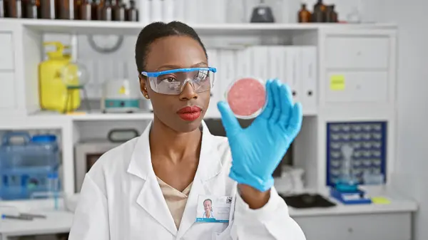 Serious african american woman scientist, fervently immersed in her work, poring over a crucial sample at the lab, encapsulating the strength of black, female professionals in science.