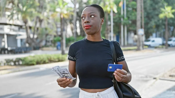 严重的非洲裔美国妇女 持有信用卡和美元在城市街道上 — 图库照片