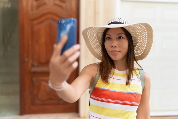 Young asian woman tourist smiling confident make selfie by smartphone at street