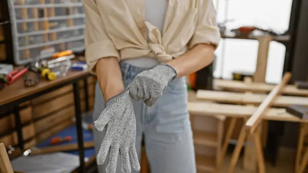 Hands wearing gloves, the world of women in carpentry and woodworking, a profession of grit, in an indoor workshop