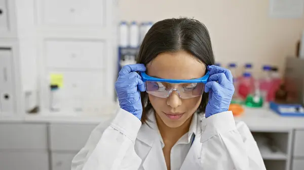 Gericht Jonge Vrouw Aanpassen Veiligheidsbril Een Moderne Laboratoriumomgeving — Stockfoto