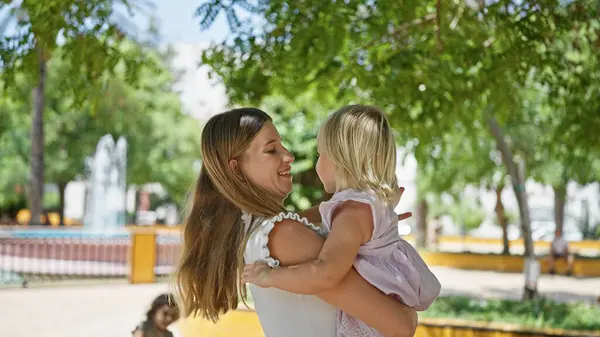 Sebevědomá Matka Objímající Svou Dceru Radostně Usmívající Sluncem Zalitém Parku — Stock fotografie
