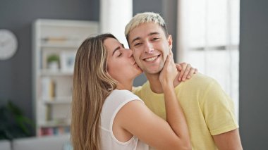 Güzel çift gülümsüyor. Kendilerine güveniyorlar. Evde öpüşüyorlar.