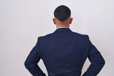 Genç İspanyol takım elbiseli ve kravatlı adam kolları vücudunda geriye doğru bakıyor. 