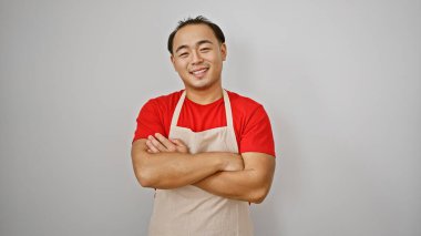 Kendine güvenen genç Çinli bir adam, kollarını kavuşturmuş gülümseyen bir garson, beyaz arka planda tek başına duruyor, ürpertici iş titreşimleri yayıyor.