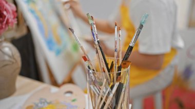 Sanat stüdyosunda resim çizen genç bir İspanyol.