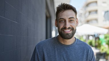 Sokakta kendinden emin gülümseyen İspanyol genç adam.