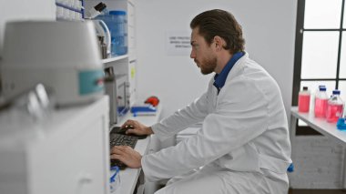 Laboratuvarda bilgisayar kullanan genç İspanyol bilim adamı.