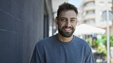 Sokakta kendinden emin gülümseyen İspanyol genç adam.