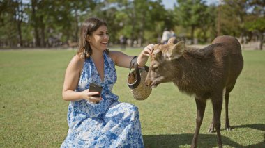 Yaz tatili zevki, güzel İspanyol kadın güneşli bir günde Nara 'da leziz bir dondurma külahının tadını çıkarıyor, Japonya' nın enfes parkı, neşeli gülümsemesi tatil eğlencesi ve açık hava maceralarını yansıtıyor.