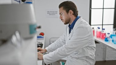 Laboratuvarda bilgisayar kullanan genç İspanyol bilim adamı.