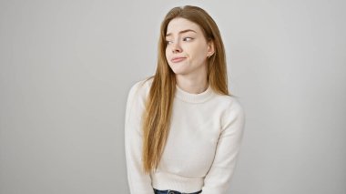 Uzun sarı saçlı, beyaz bir süveter giyen, izole edilmiş beyaz arka planda şüpheli genç bir kadının portresi..