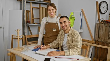 Marangozluk stüdyosunda gülen adam ve kadın, marangozluk aletleri ile, tasarım planlama.