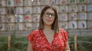 Enigmatik ifade. Güzel İspanyol kadın. Gözlük takıyor. Tokyo Meiji Tapınağı 'nda dimdik duruyor..