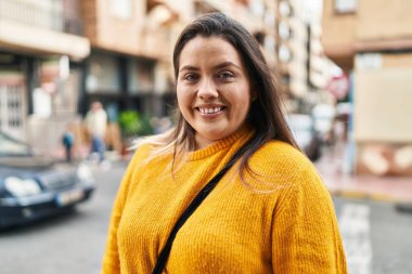 Young beautiful plus size woman smiling confident standing at street