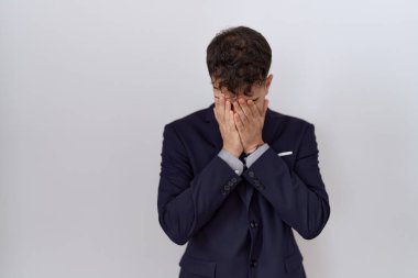 Ağlarken yüzünü ellerle kapatan takım elbiseli ve kravatlı İspanyol bir iş adamı. depresyon kavramı. 