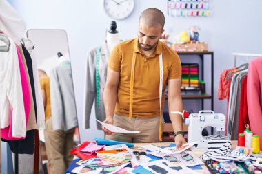 Genç latin adam parkta terzi görünümlü kıyafet tasarımı