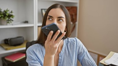 Güzel Latin kökenli genç bir kadın işçi, patron ve profesyonel. Ofisteki akıllı telefondan ciddi bir sesli mesaj gönderiyor. İş yerinde yapılan konuşmalarda başarıyı gösteriyor.