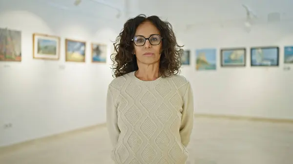 Mature Hispanic Woman Glasses Standing Thoughtfully Art Gallery Portraying Sense — Stock Photo, Image